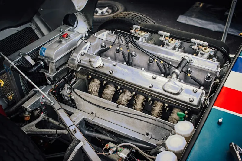 Klasik bir otomobilin açık motor bölmesi: cilalı silindir kapağı ve karbüratörler.