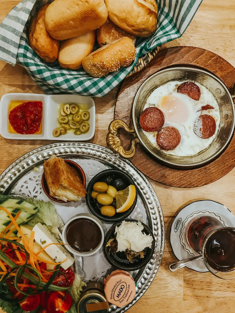 Ahşap yuvarlak tepside peynir, zeytin, yumurta ve simitle kurulmuş bir Türk kahvaltısı