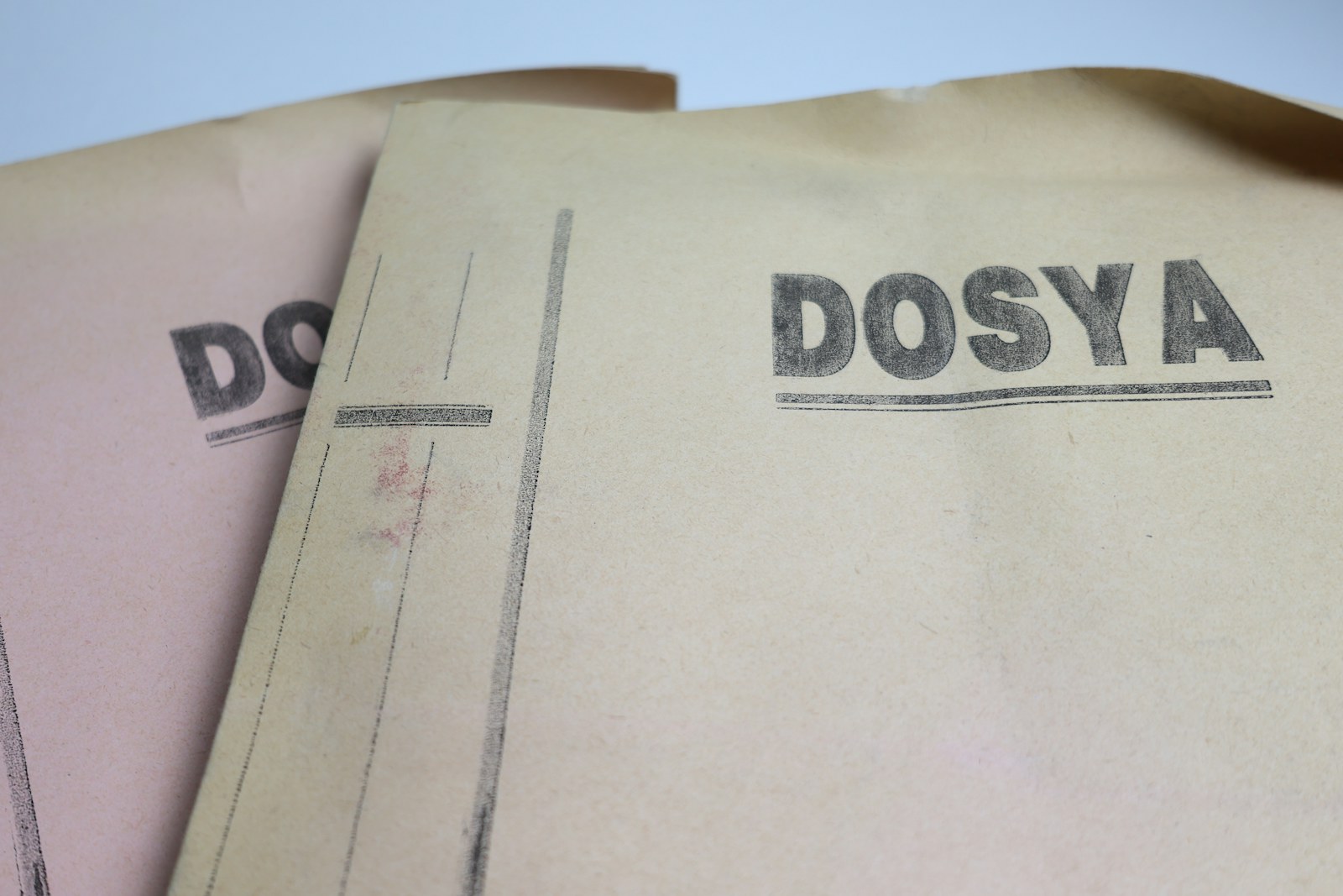 Üzerinde “DOSYA” yazan iki eski karton dosya